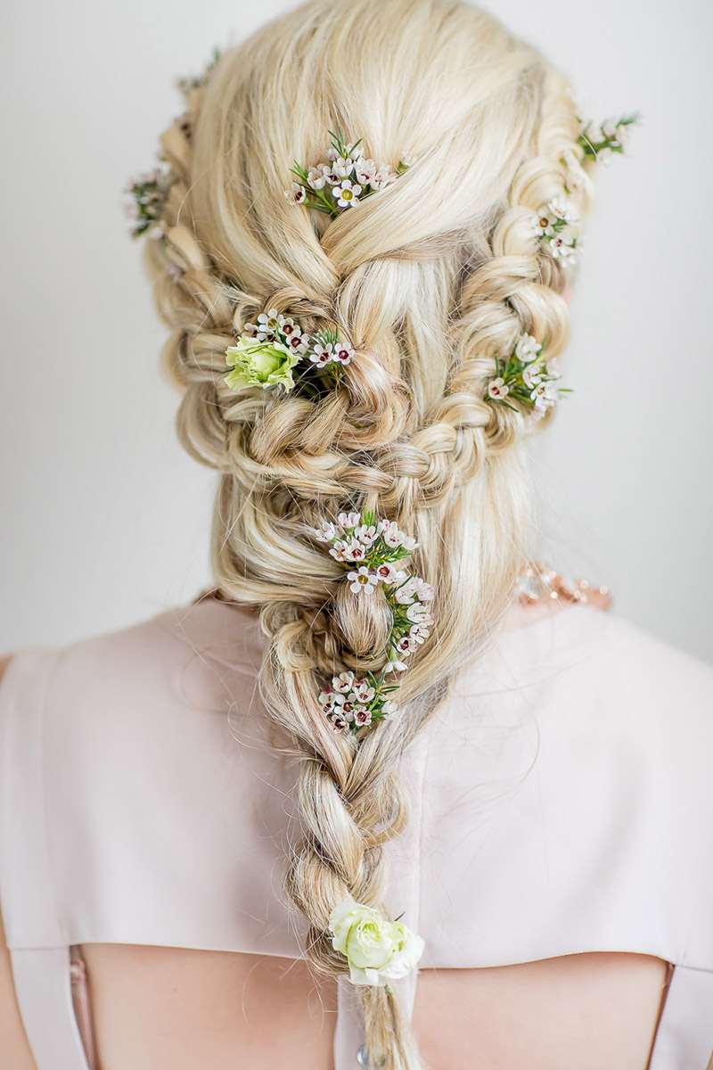 Brautfrisur geflochten mit frischen Blumen für lange Haare