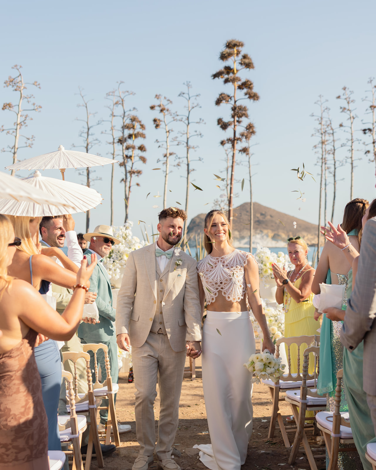 Katharina und Roman strahlen beim Auszug nach der Zeremonie, Konfetti, jubelnde Gaeste, Strand von Cabo de Gata