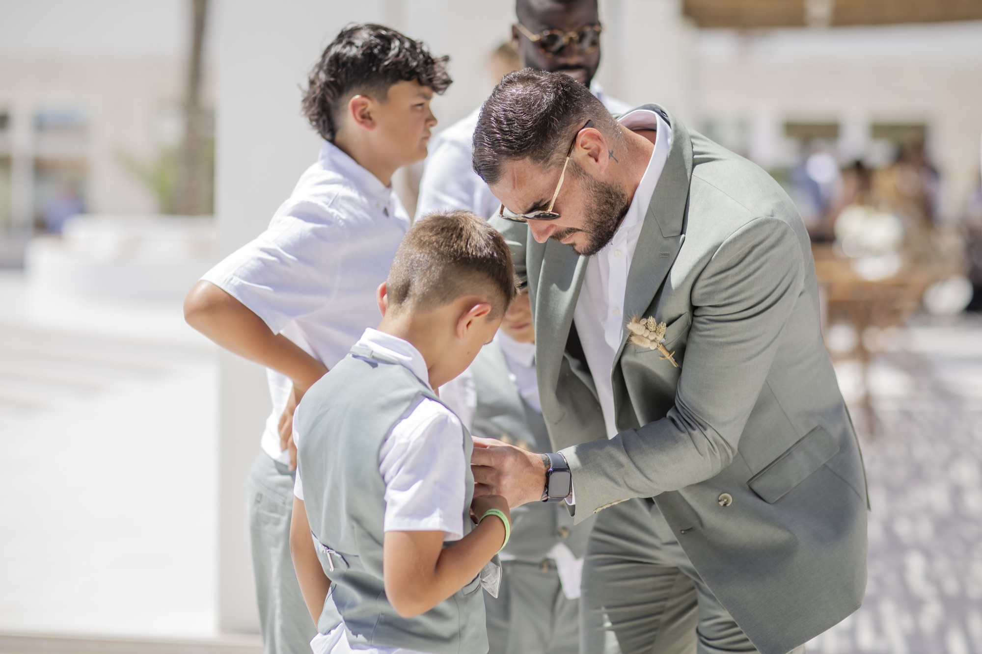 Braeutigam hilft kleinem Jungen mit dem Anzug, El Paraiso al Mar Guardias Viejas, Strandhochzeit Andalusien