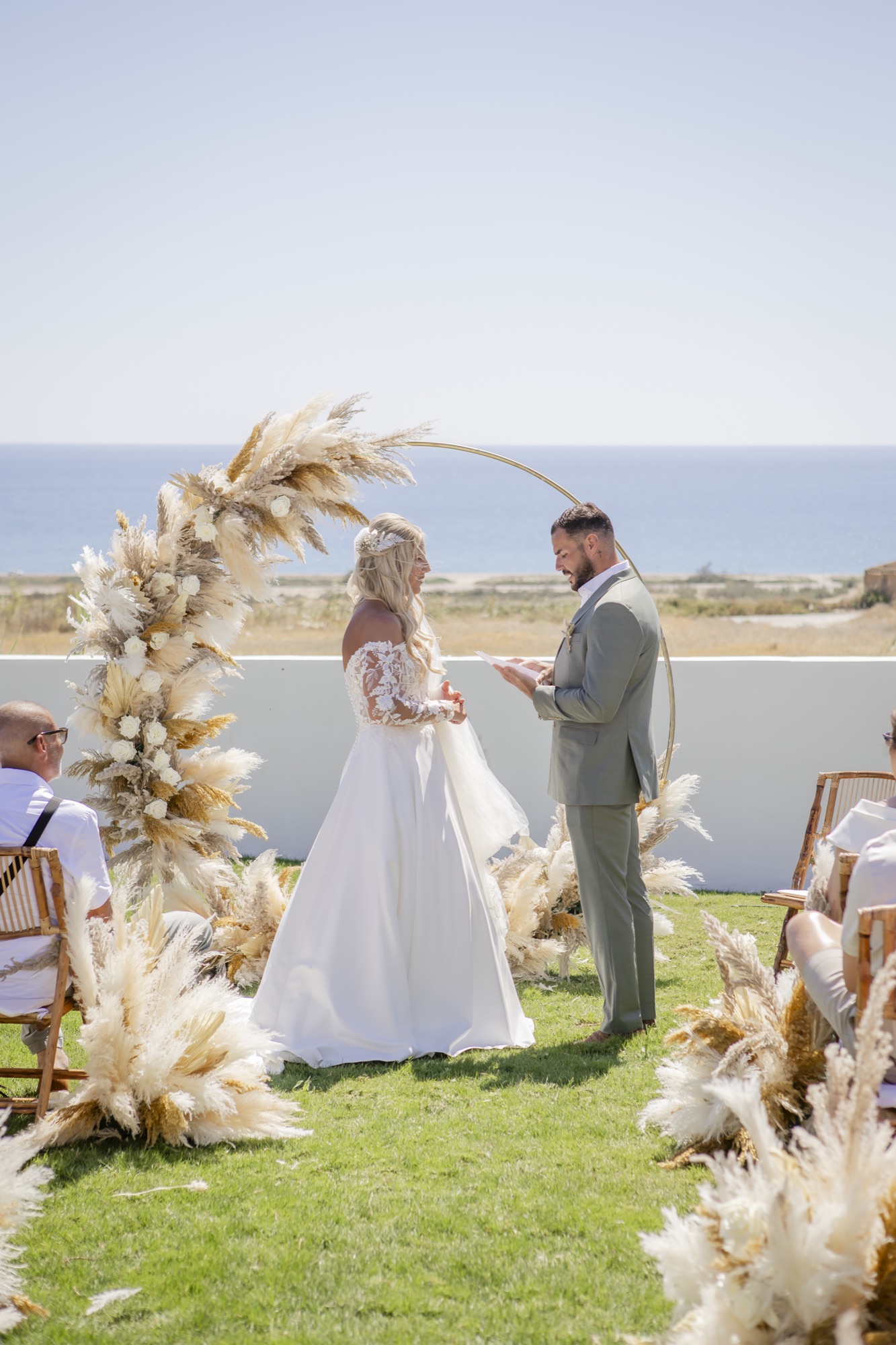 Brautpaar beim Eheversprechen unter dem Pampas-Traubogen, El Paraiso al Mar Guardias Viejas, Destination Wedding Andalusien