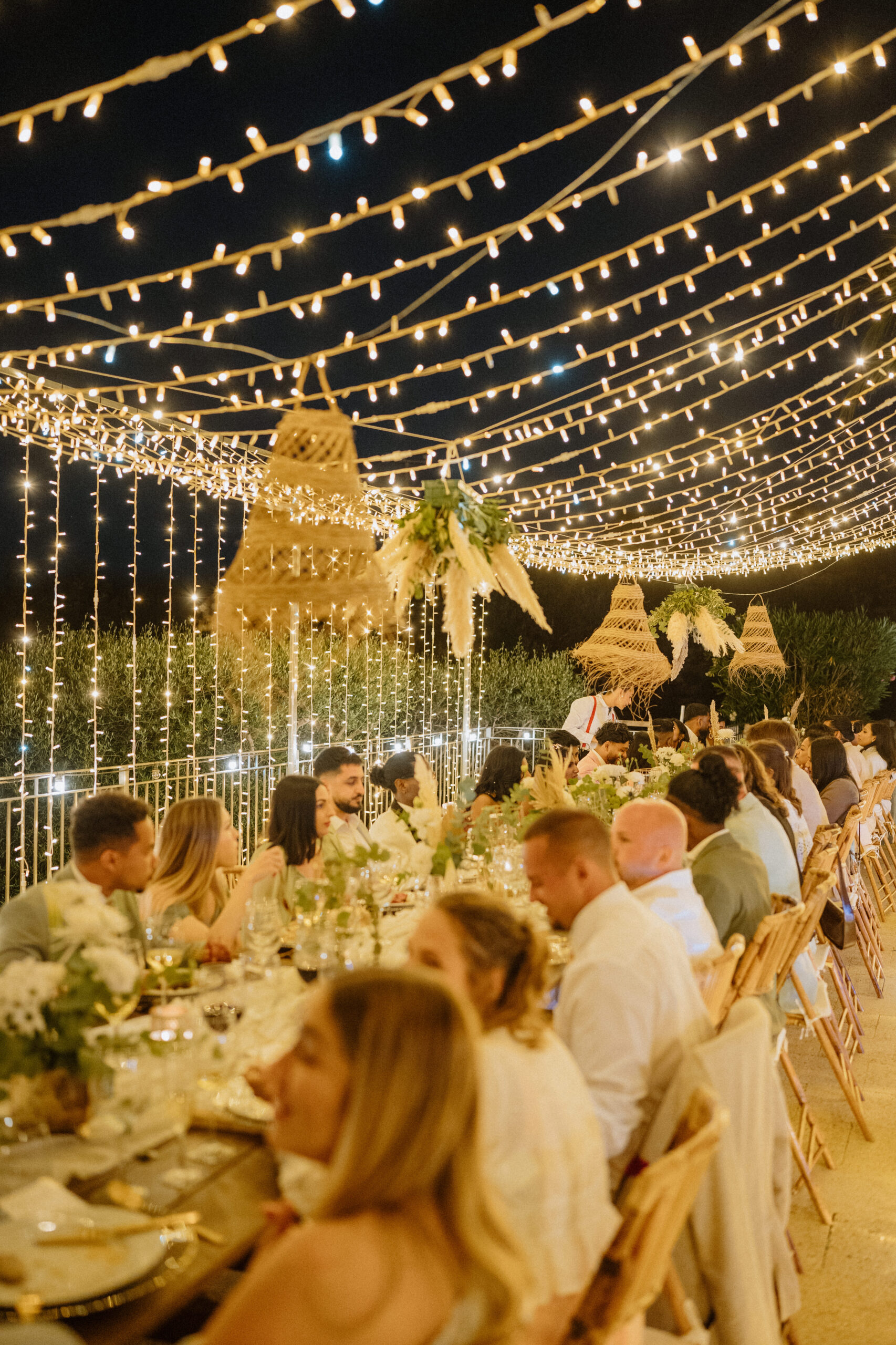 Dinner bei Nacht mit Lichterketten und Gästen, Outdoor Hochzeit Spanien