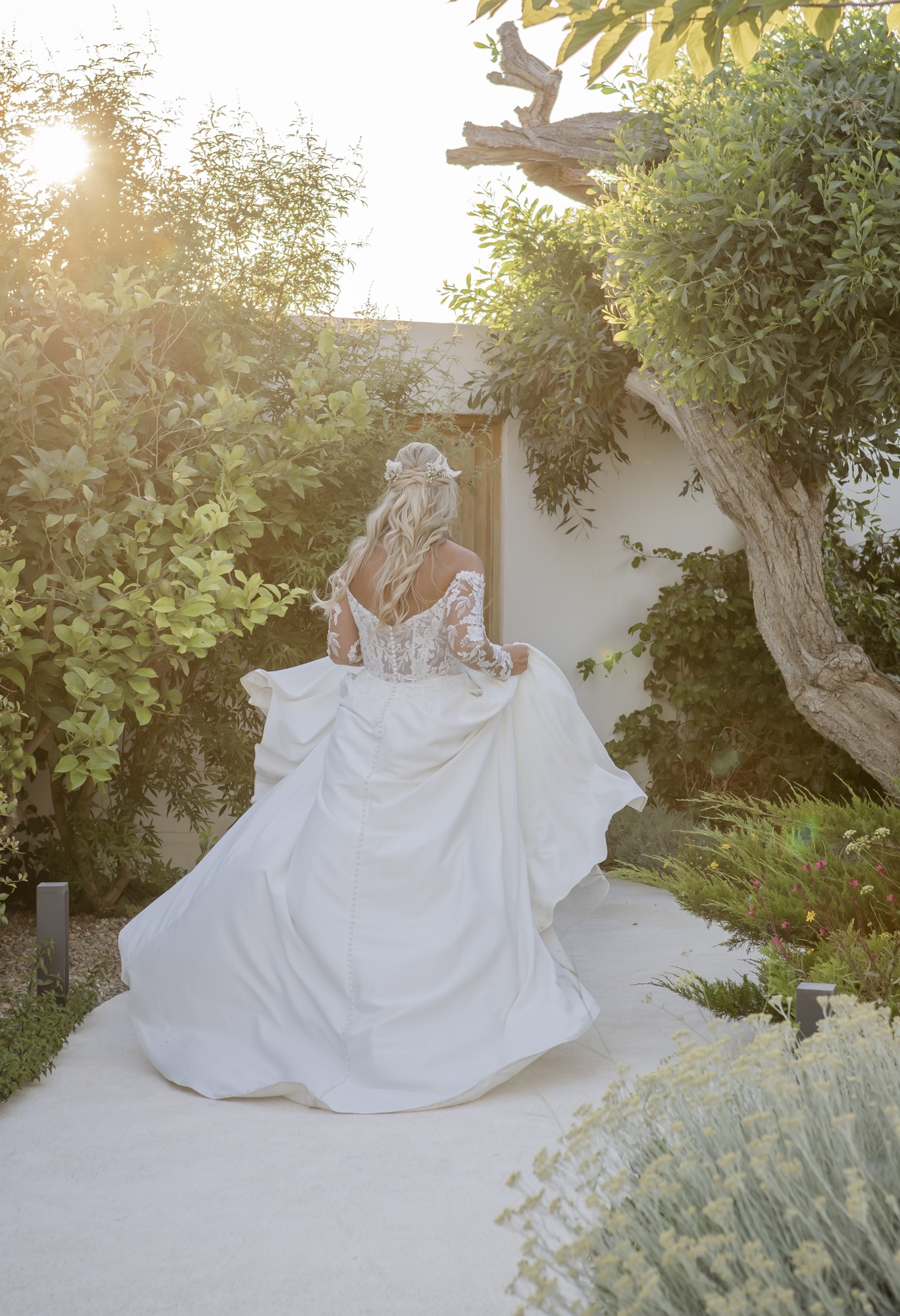 Braut im Spitzenkleid von hinten im Garten, El Paraiso al Mar Guardias Viejas, Boho-Hochzeit