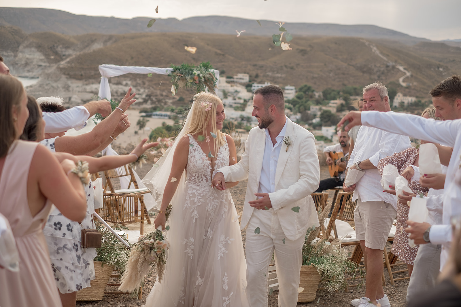 Auszug des Brautpaares Lara und Michael durch ein Spalier mit Blütenregen, Lara lacht, Cabo de Gata