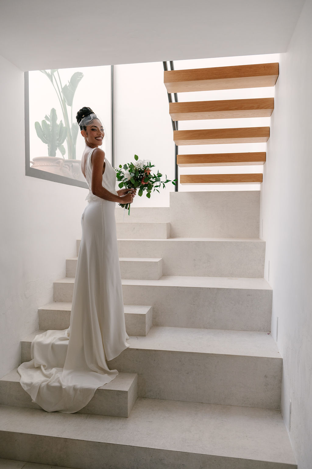 Braut mit Brautstrauß auf der Treppe der Hochzeitslocation, Cabo de Gata, elegante Hochzeit