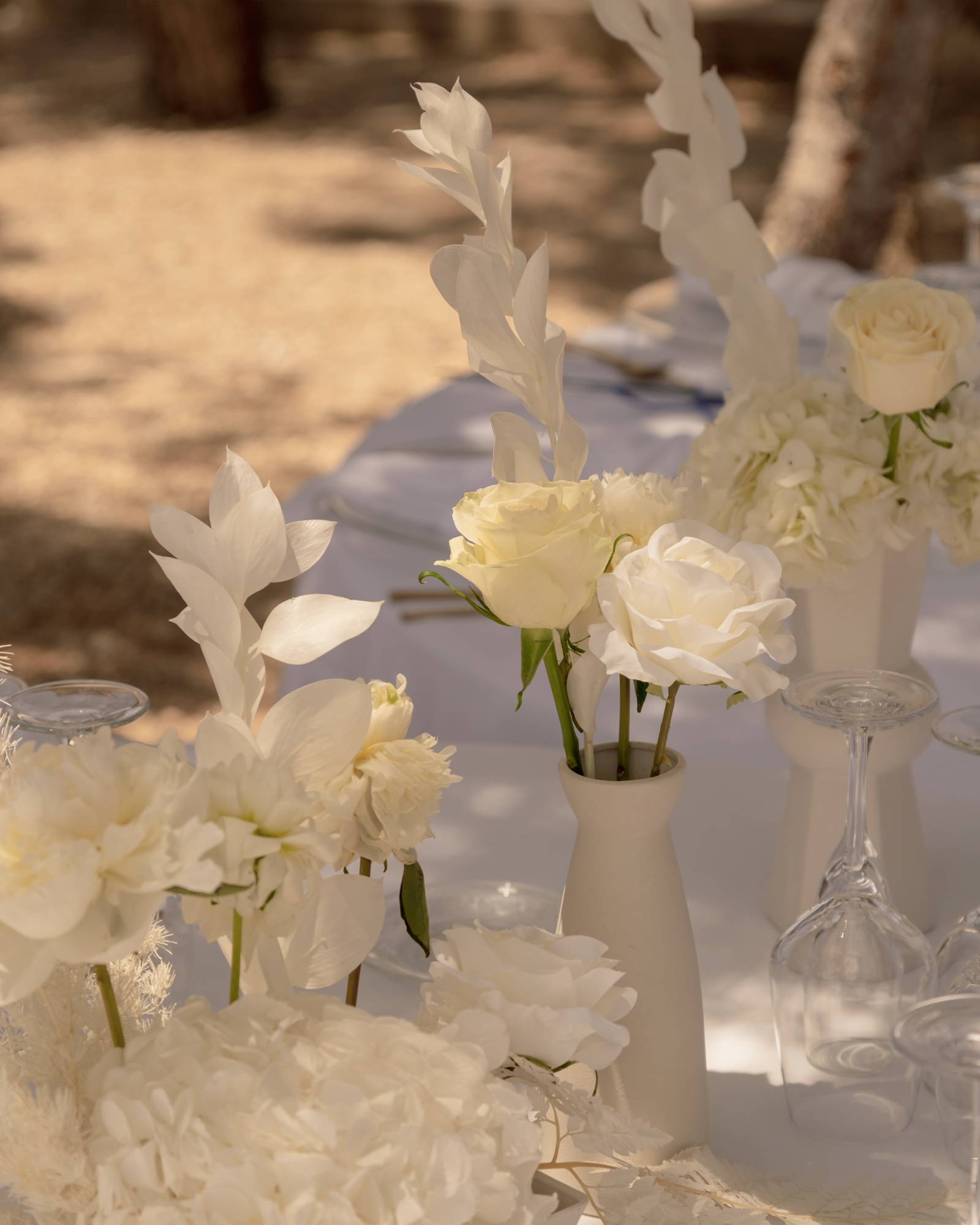 Tischdeko mit weißen Rosen und Pfingstrosen in Keramikvasen, Location 17 Cabo de Gata, Hochzeit ganz in Weiß