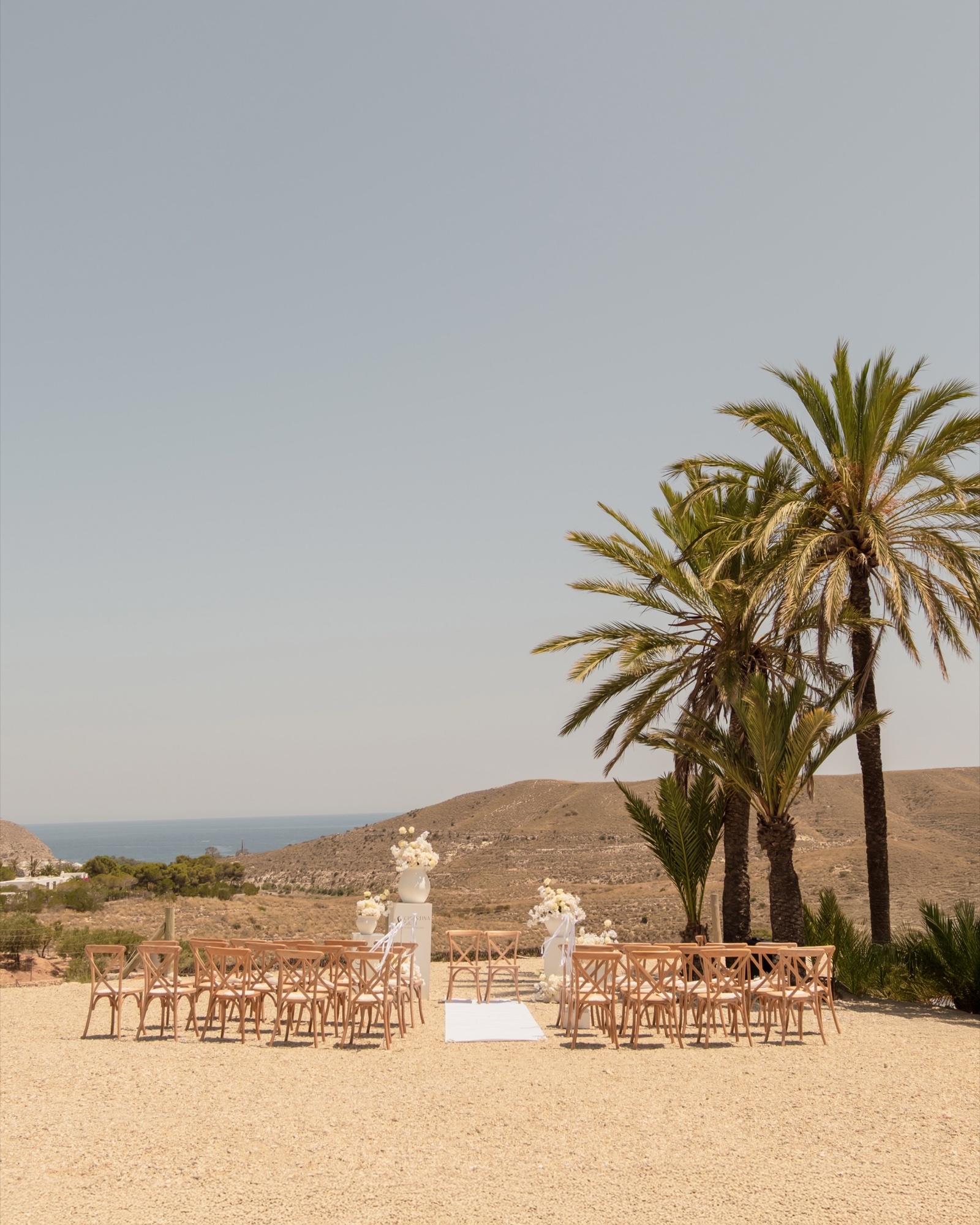 Zeremonie-Setup mit Cross-Back-Stühlen, Palmen und Meerblick, Location 17 Cabo de Gata, Hochzeit im Freien