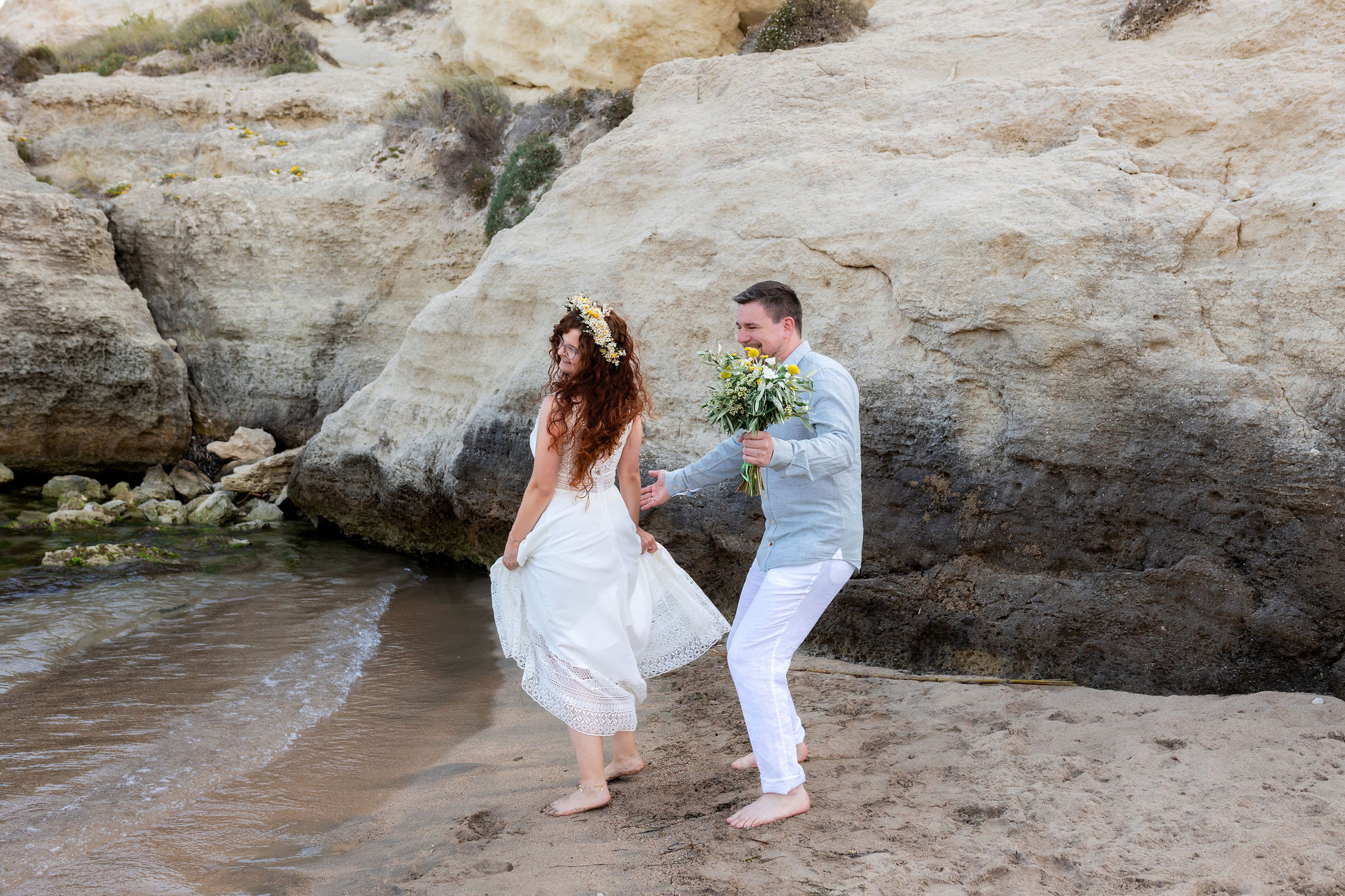 Brautpaarportrait an den hellen Sandsteinfelsen der Bucht, Agua Amarga, Boho Strandhochzeit Cabo de Gata
