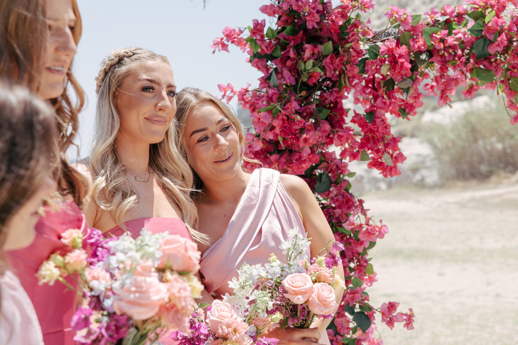 Bridesmaids in pink with flower bouquets, Agua Amarga, beach wedding