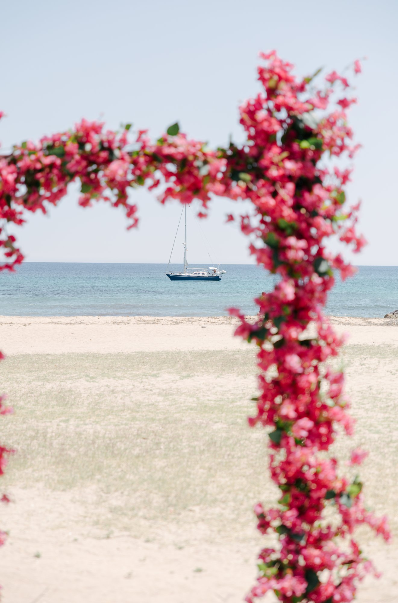 Bougainvillea arch with a view of the sea and a sailing boat, Cabo de Gata, beach wedding