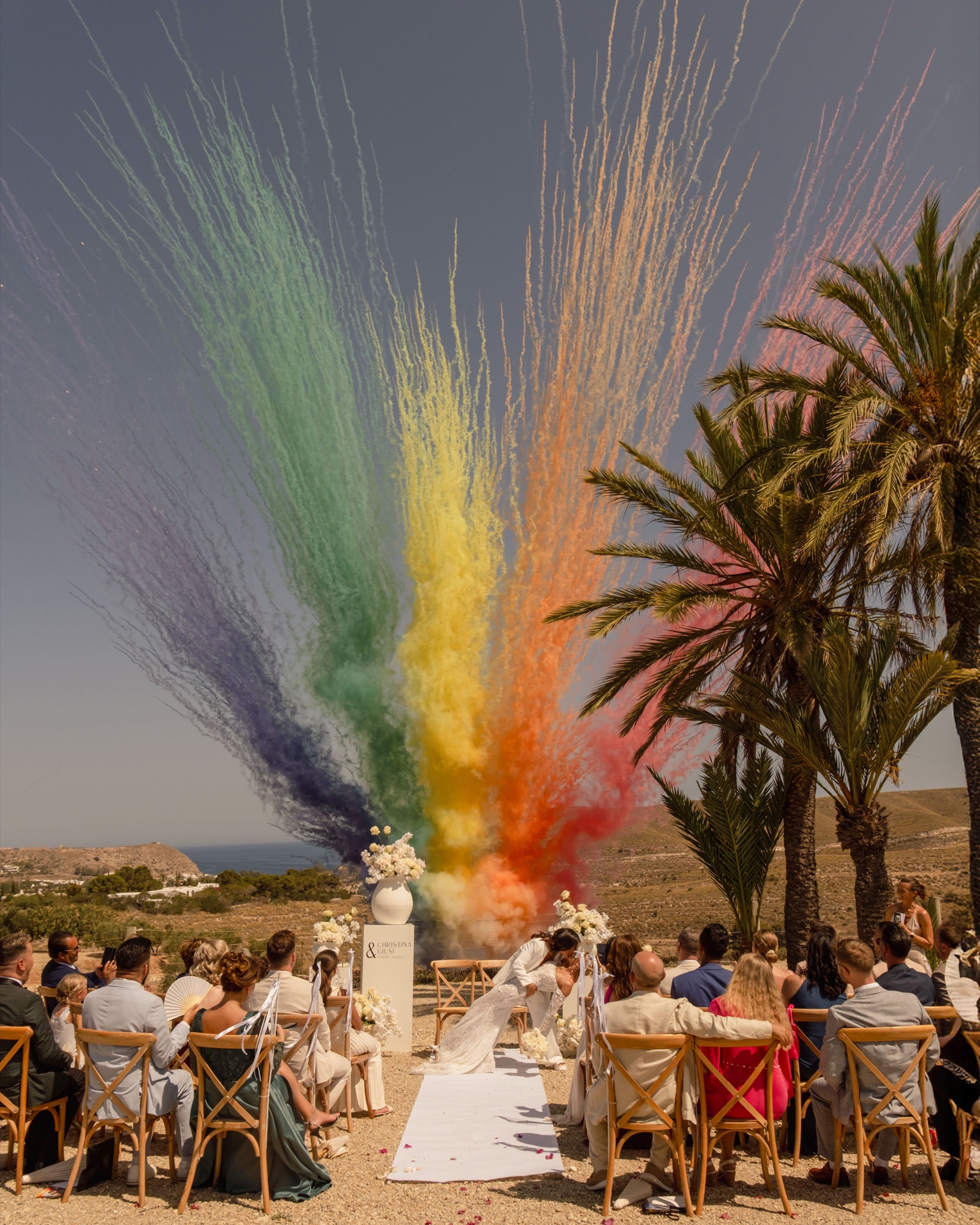 Regenbogenfarbene Rauchfontänen über der Zeremonie am Meer, Location 17 Cabo de Gata, gleichgeschlechtliche Hochzeit in Spanien