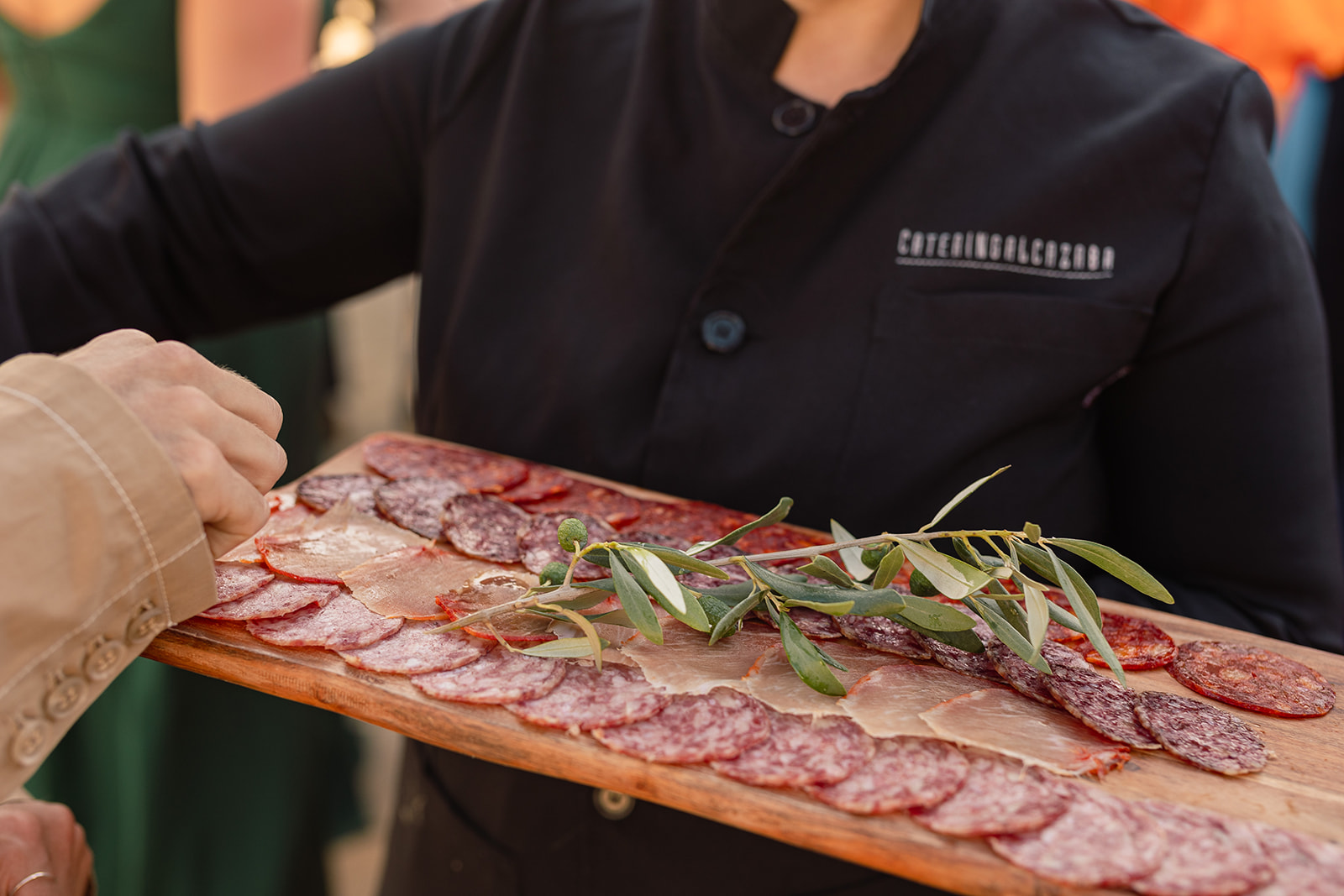 Kellner serviert spanische Wurstplatte mit Olivenzweig beim Aperitif, Mojácar, Finca Hochzeit Andalusien