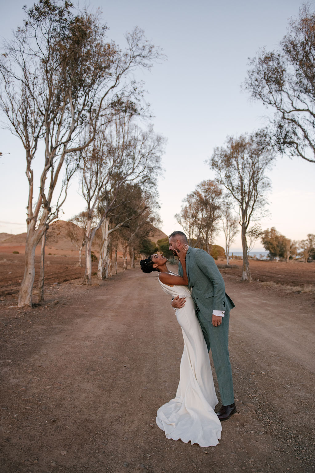 Brautpaar beim Dip-Kuss auf der Eukalyptus-Allee, Cabo de Gata, elegante Hochzeit