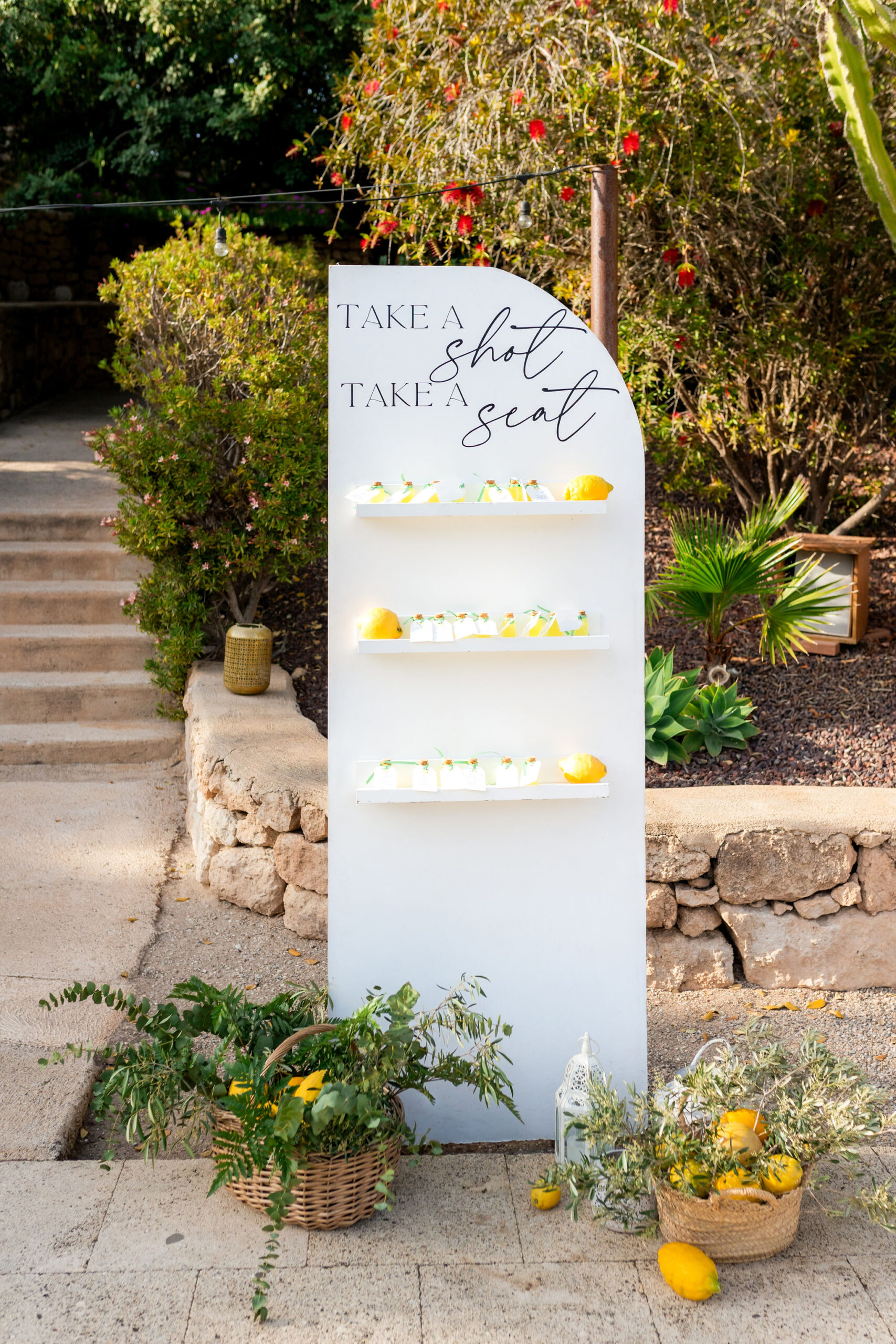 Sitzplan mit Limoncello-Fläschchen und Zitronendeko, Take a shot take a seat, Boho Strandhochzeit Cabo de Gata