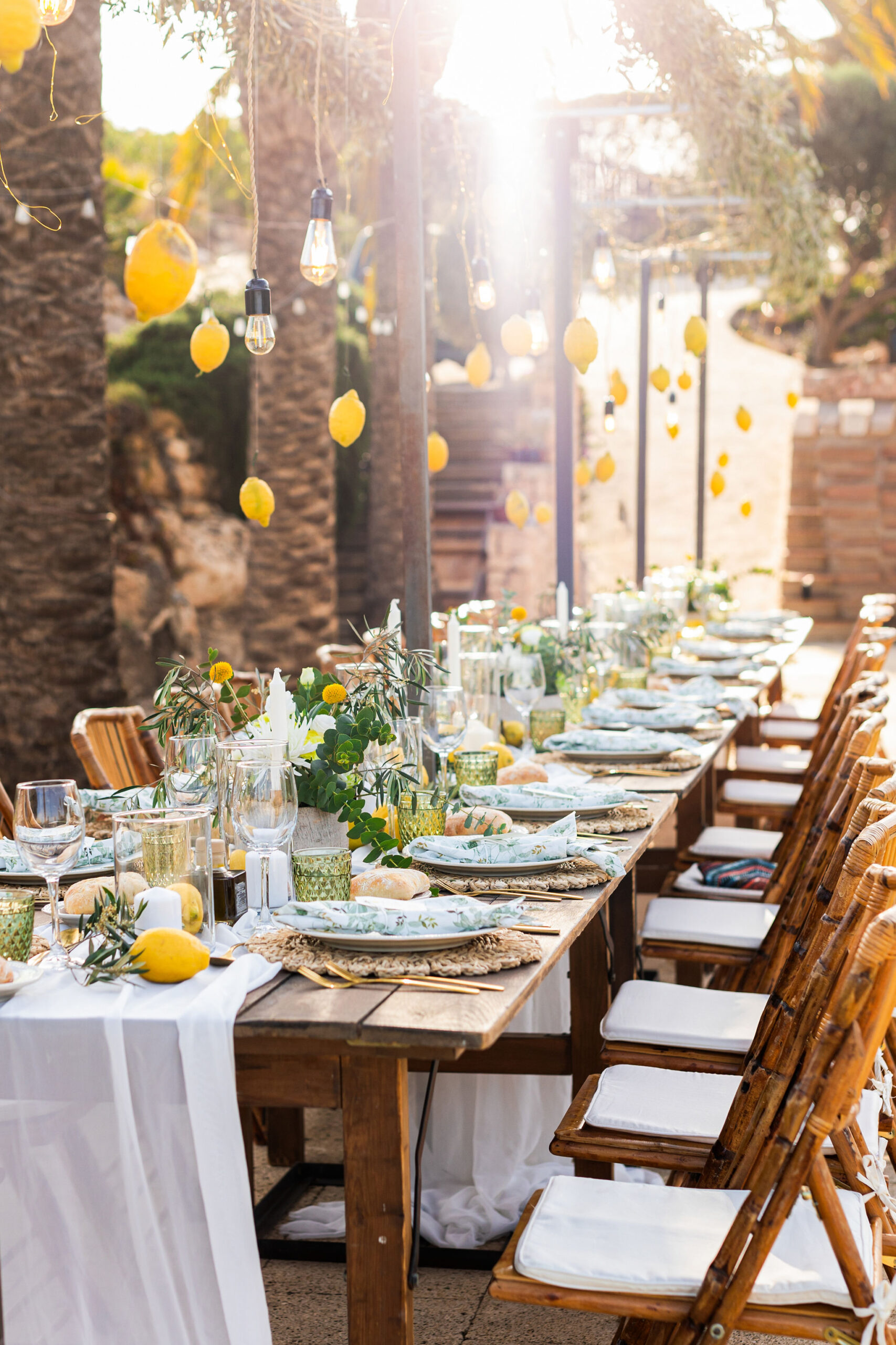 Hochzeitstafel mit hängenden Zitronen und Lichterketten am Pool im Abendlicht, Boho Strandhochzeit Cabo de Gata