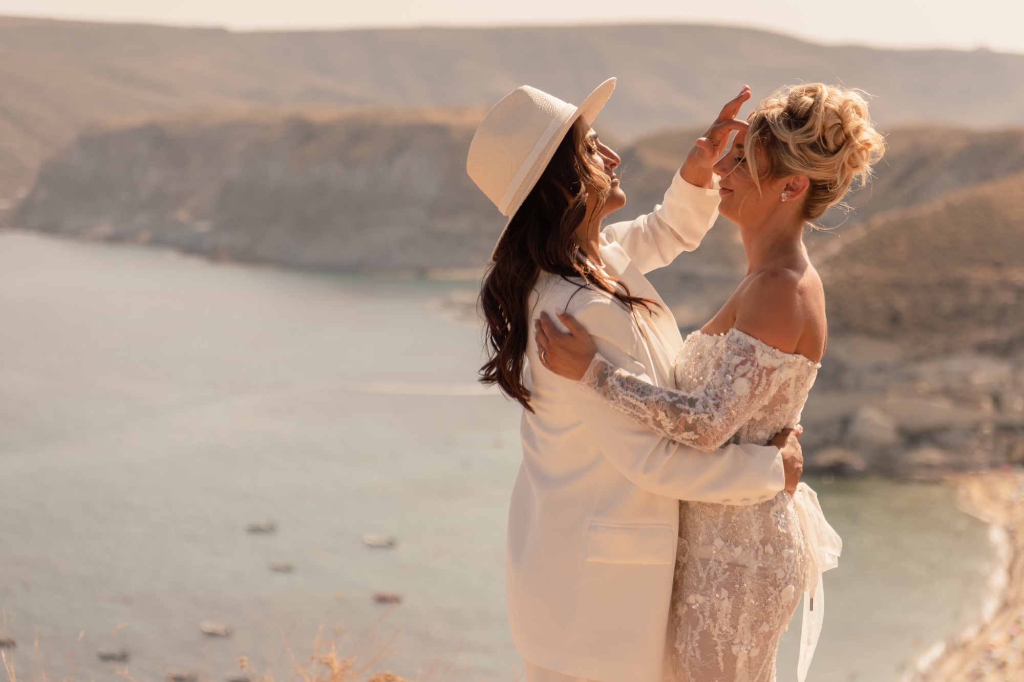 Eine Braut streicht der anderen übers Haar, Bucht im Hintergrund, Cabo de Gata, Brautpaarporträt
