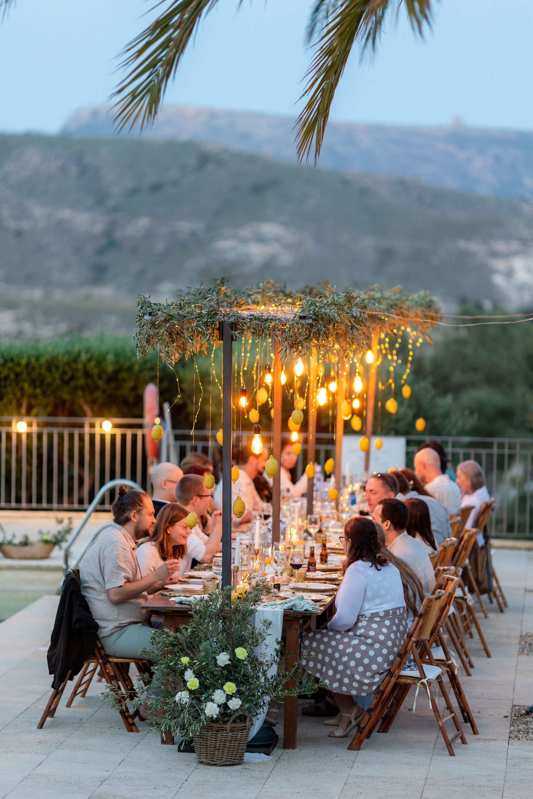 Hochzeitstafel in der blauen Stunde mit leuchtenden Lichterketten am Pool, Boho Strandhochzeit Cabo de Gata