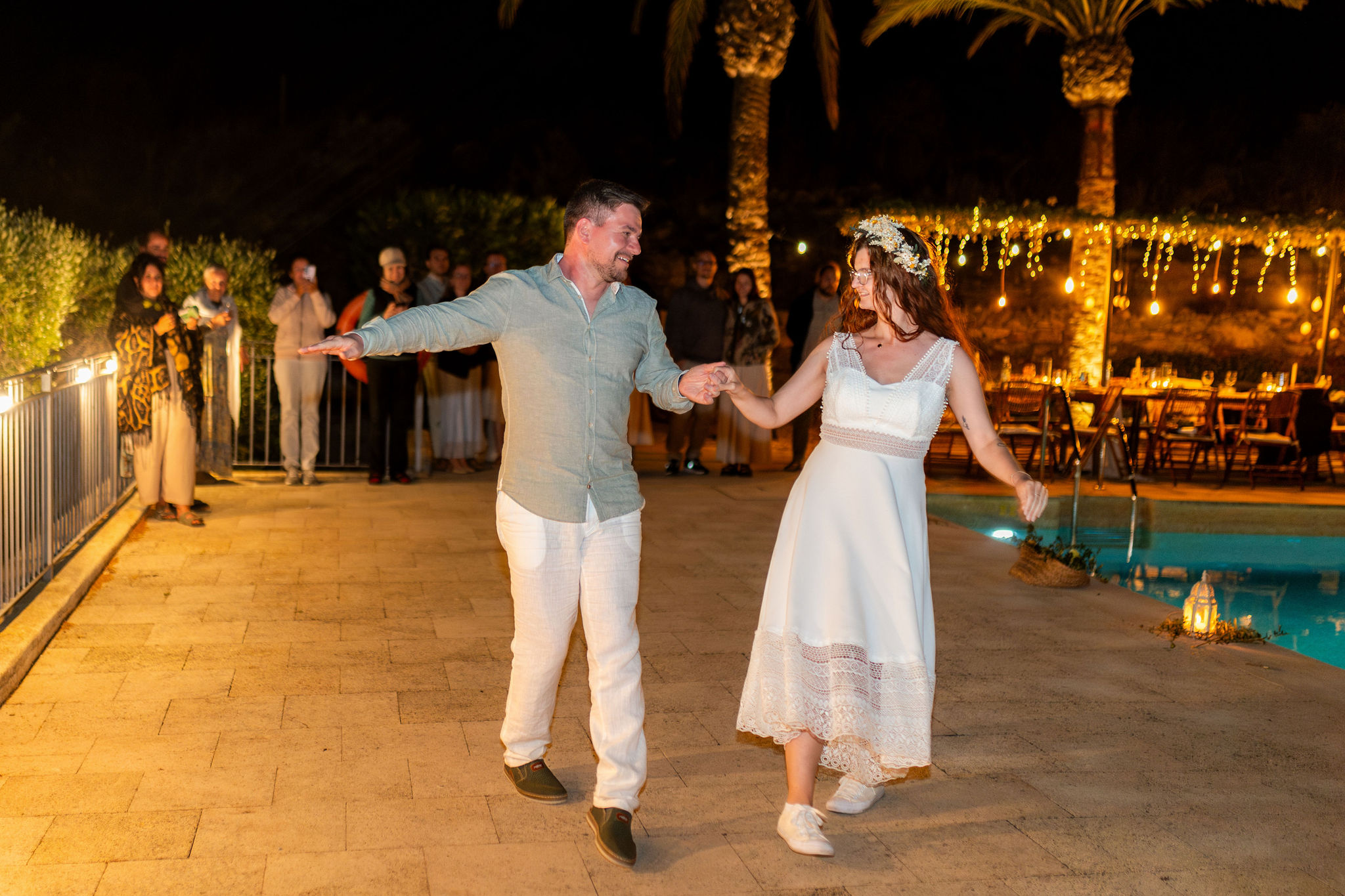 Brautpaar tanzt am Pool bei Nacht unter Lichterketten, Agua Amarga, Boho Strandhochzeit Cabo de Gata