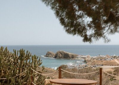 Terrasse mit Holztischen und Blick auf das Meer bei La Isleta del Moro