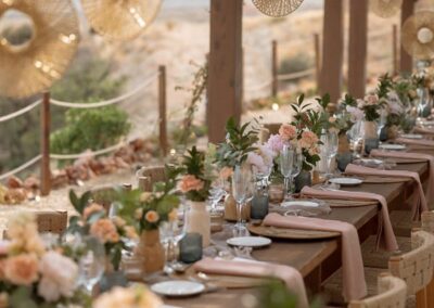 Festlich gedeckte Hochzeitstafel unter der Holzpergola mit hängenden Rattanlampen