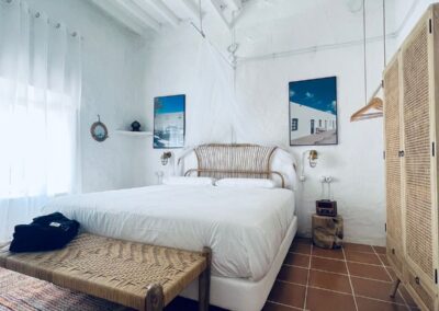 Helles weißes Schlafzimmer mit Holzbalkendecke im Cortijo bei La Isleta del Moro