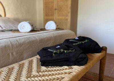 Gästezimmer mit Naturmaterialien und geflochtenem Sitzmöbel
