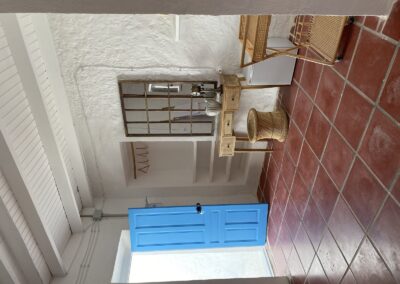 Badezimmer mit roten Fliesen und blauer Tür im Cortijo bei La Isleta del Moro