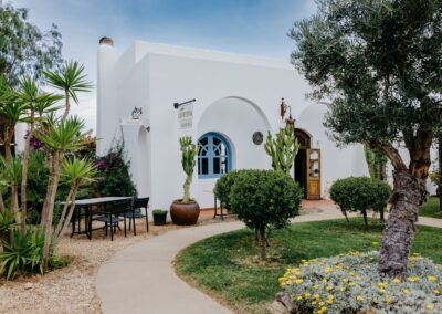 Weißes Haus mit Rundbögen und Kakteen auf der Gartenanlage bei Pozo de los Frailes