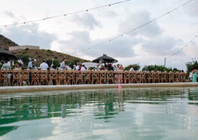 Lange Hochzeitstafel entlang des Pools in der Abenddämmerung