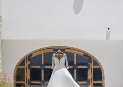 Brautkleid hängt im Rundbogen des weißen Gebäudes bei Guardias Viejas
