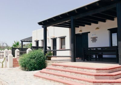 Weiß getünchtes Haupthaus der Finca über Agua Amarga mit überdachter Pergola und Freitreppe