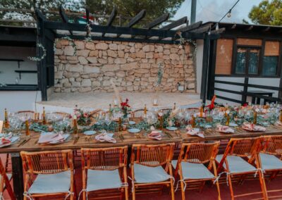Gedeckte Hochzeitstafel vor der alten Steinmauer der Finca, mediterrane Blumendeko