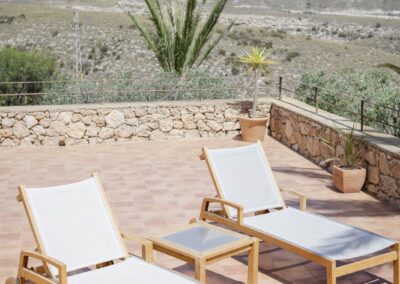 Sonnenliegen auf der Terrasse des Hotels über Agua Amarga