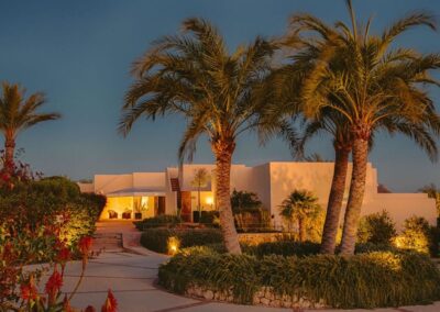Das Hotel über Agua Amarga bei Nacht mit angestrahlten Palmen