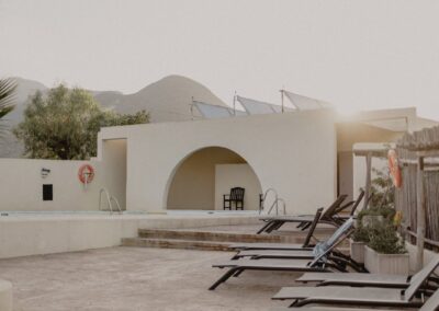 Poolterrasse mit Liegen und weiß gemauerter Rundung im Cortijo bei San José