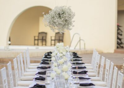 Elegant gedeckte Hochzeitstafel in Weiß und Schwarz unter Lichterketten, Cortijo San José