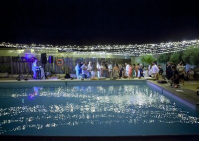 Hochzeitsparty am beleuchteten Pool des Cortijo bei Nacht