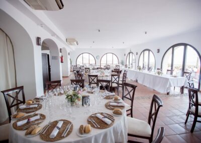 Heller Innenraum des Cortijo mit runden Hochzeitstischen
