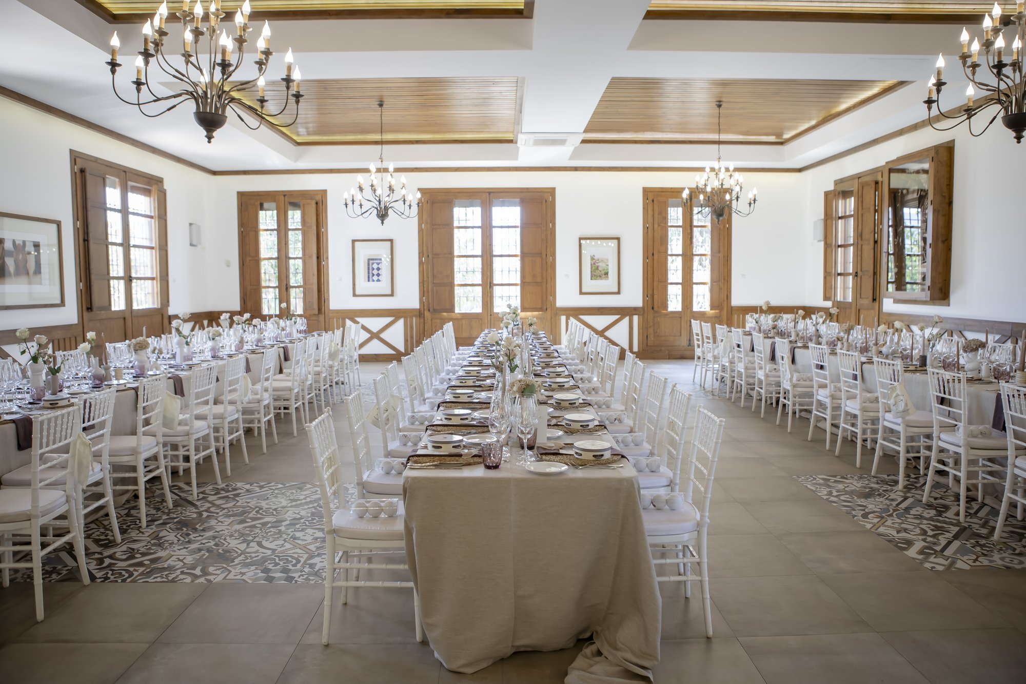 Festsaal mit Kronleuchtern und langen Tafeln, Hacienda Hochzeit Andalusien