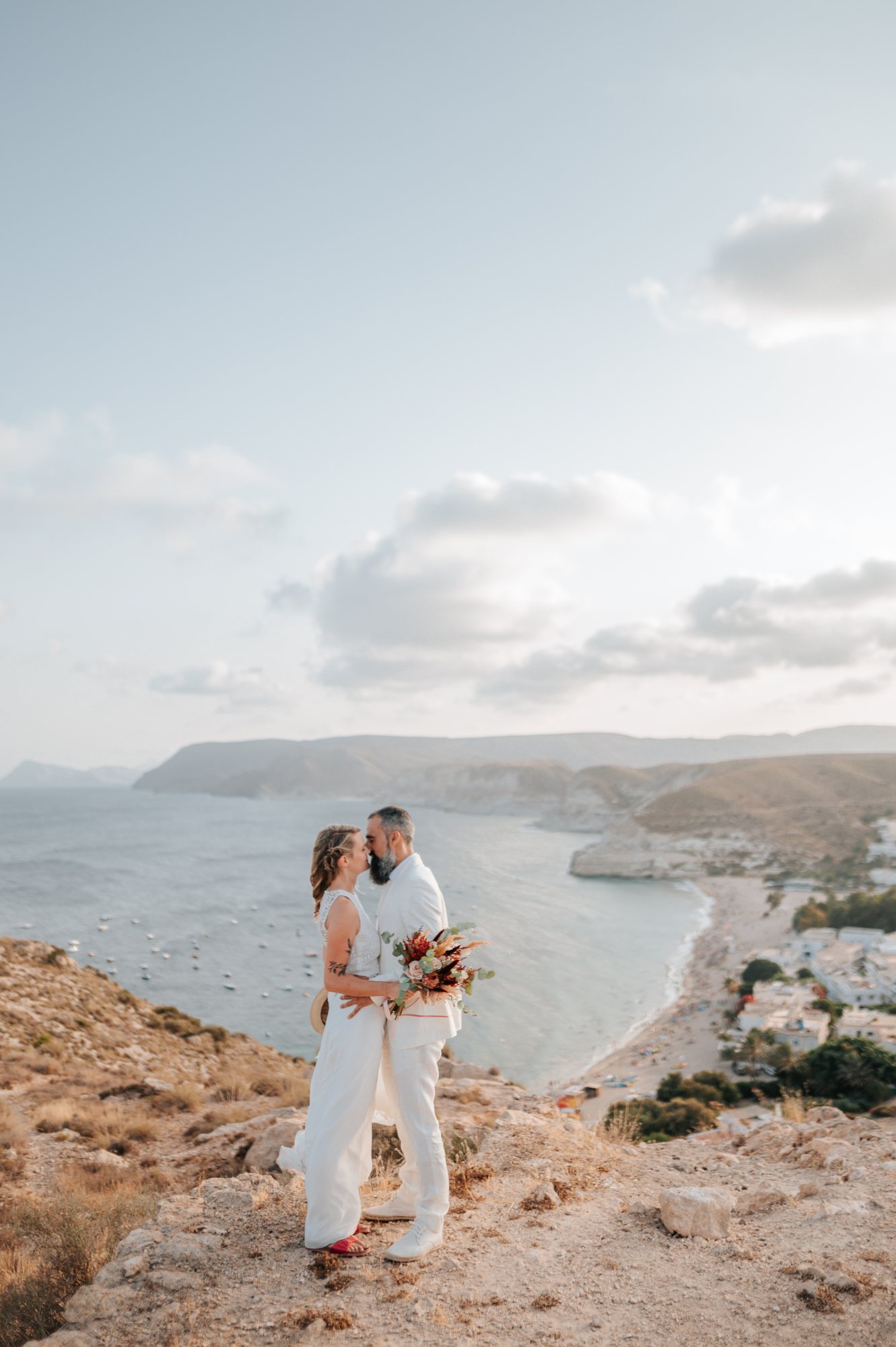 Kuss des Brautpaars über dem Meer, Hochzeit am Meer in Spanien