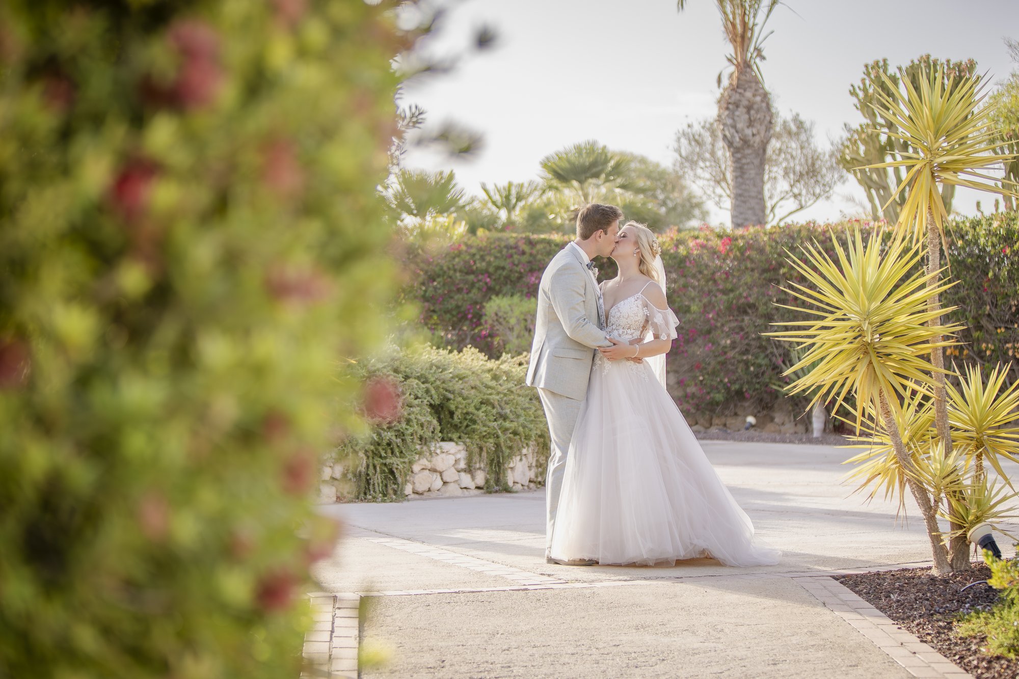 Couple in the hotel garden among palms and blossoms, wedding Agua Amarga